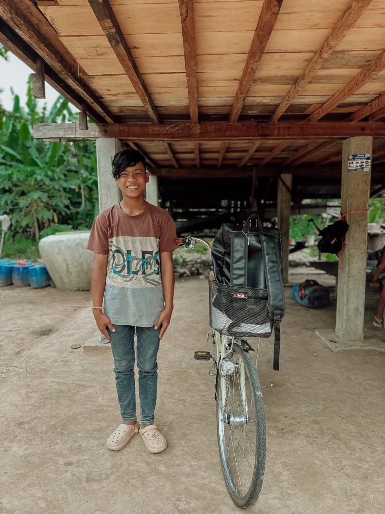 Junge erhält Fahrrad, damit er in die Schule gehen kann.